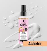 Bouteille de produit liquide rose sur fond blanc avec effets de gouttelettes d'eau.