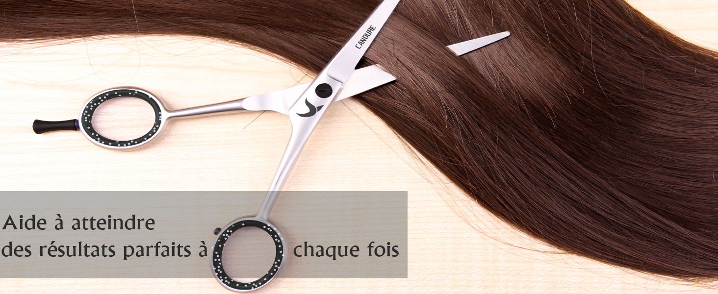 une paire de ciseaux qui coupe un cheveu brun.