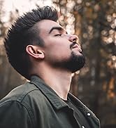Vue de profil d'un homme aux cheveux courts et noirs et à la barbe, les yeux fermés, portant une veste foncée à l'extérieur avec un fond naturel flou