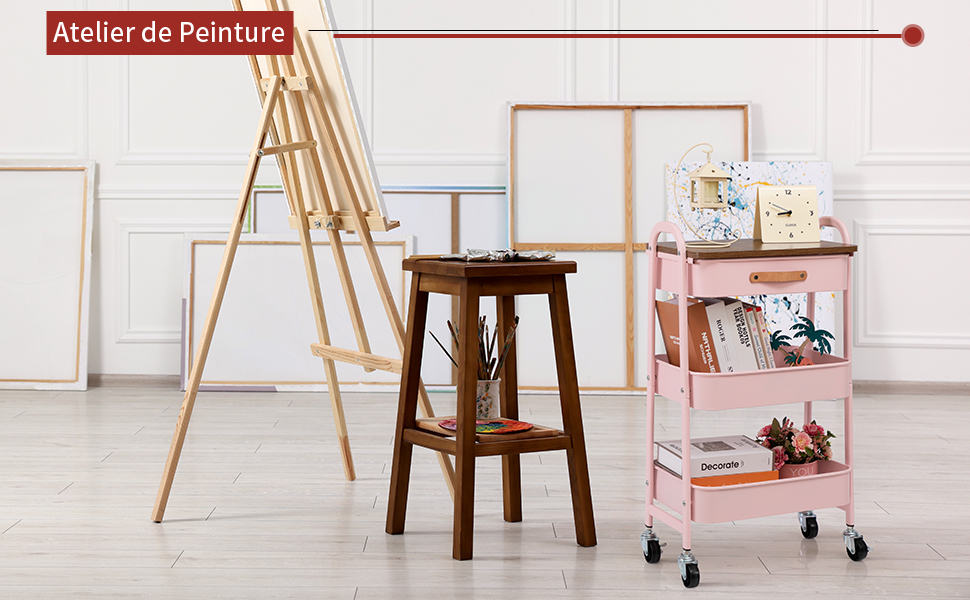 avec chevalet en bois, tabouret en bois brun et chariot roulant en métal rose avec plusieurs étagères sur des murs blancs
