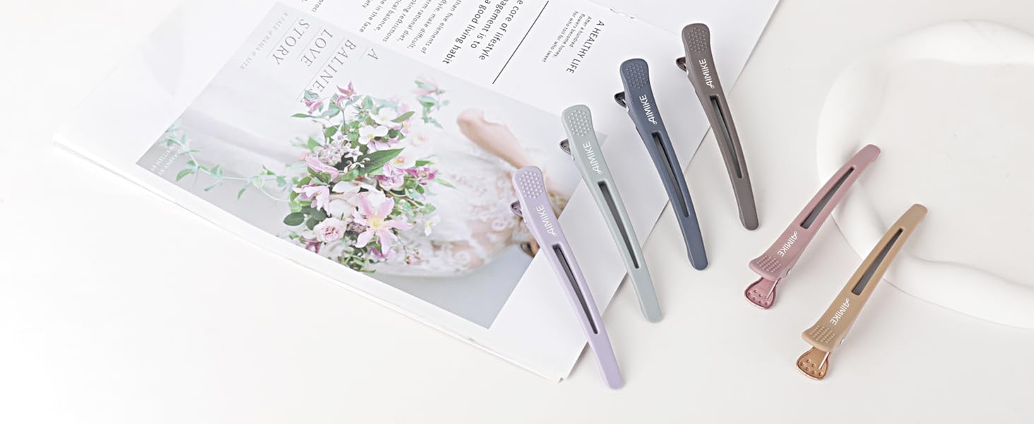 Collection de barrettes à cheveux sur fond blanc, avec différentes finitions métalliques dans les tons gris, or rose et doré. Certaines pinces décoratives présentent des motifs texturés ou scintillants