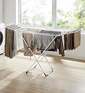 Séchoir blanc extensible placé près de la fenêtre, pouvant contenir plusieurs articles pour les faire sécher à l'air libre. Dispose d'un design de style accordéon avec plusieurs