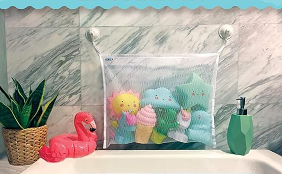 avec sac en filet contenant des jouets de bain colorés, une figurine de flamant rose, un distributeur de savon vert et une plante en pot sur une surface en marbre