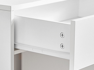 Détail d'un tiroir ou d'une armoire en bois blanc, présentant une surface lisse et deux poignées ou boutons circulaires en métal pour l'ouverture