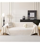 Le texte indique « LIVE LOVE ». Cadre de salon minimaliste avec housse de canapé blanche, lampe de table noire et cadres décoratifs sur une étagère noire contre un mur lambrissé blanc.