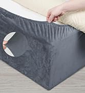 Gros plan des mains ajustant ou manipulant un tissu gris foncé ou une housse en matériau à bords élastiques