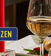 un verre de vin avec une bougie en arrière-plan