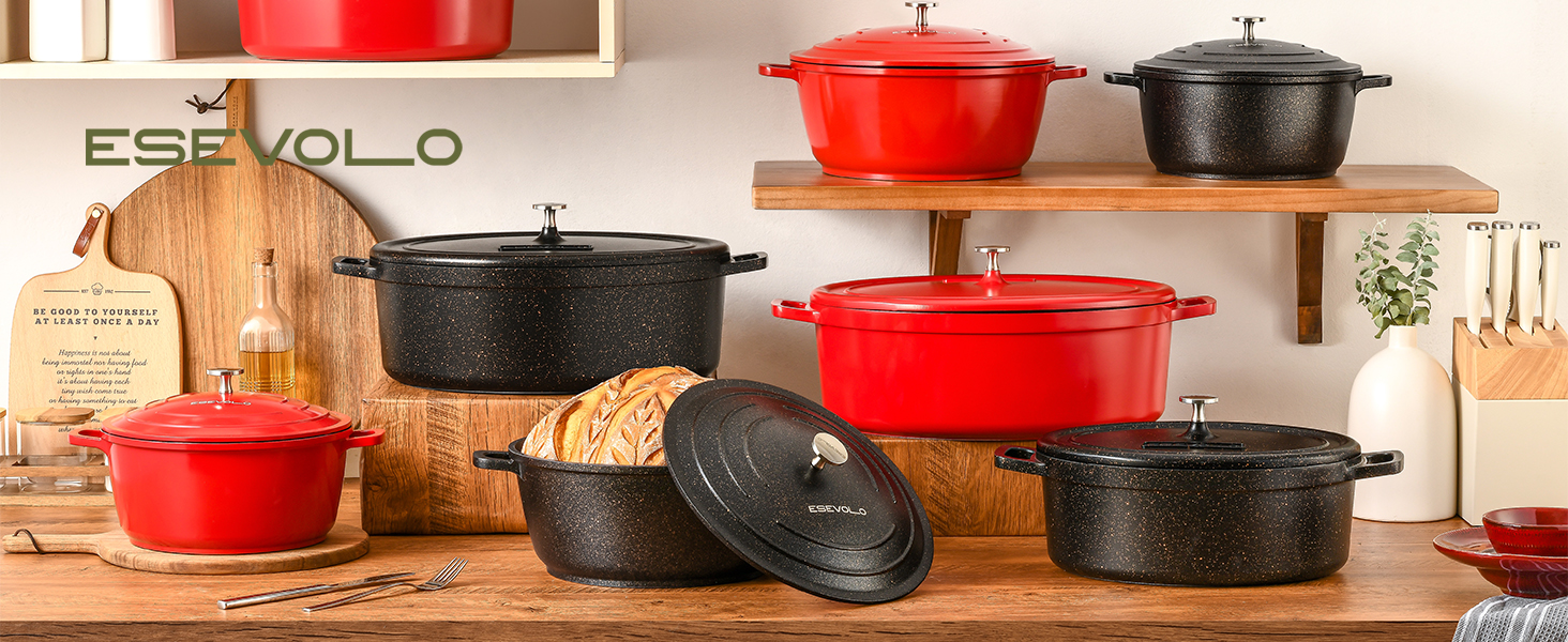 Collection d'ustensiles de cuisine en fonte rouge et noire exposés sur un comptoir en bois, y compris des fours hollandais et des casseroles de différentes tailles avec couvercles. Cadre de cuisine rustique avec fond en bois.