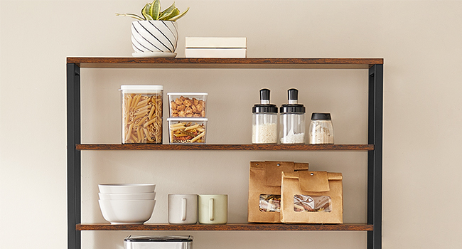 Étagère moderne en métal noir et bois présentant des contenants de rangement, des bocaux en verre et des bouteilles dans un agencement minimaliste