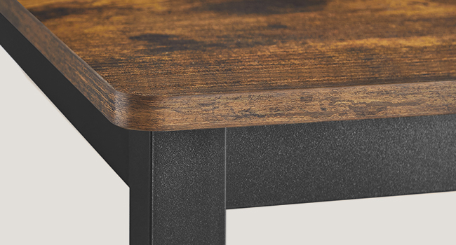 Vue en angle d'une table ou d'un comptoir avec une surface en bois foncé et un bord ou un cadre en métal noir